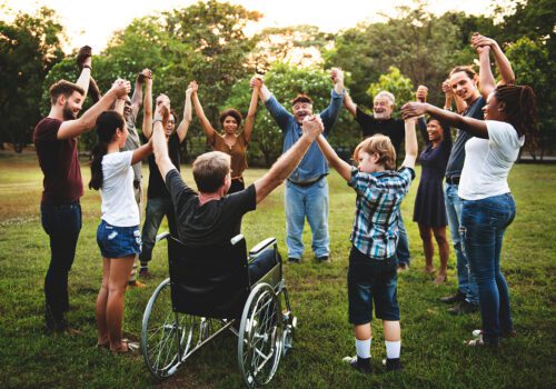 Group of people holding hands together in the park