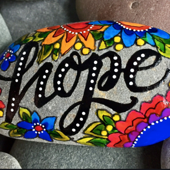 Word hope is written artistically on a rock